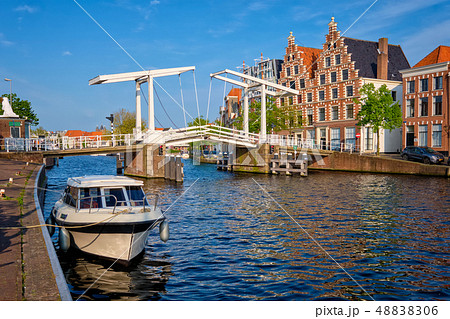 Spaarne river with boat and Gravestenenbrug bridge in Haarlem, Netherlands 48838306