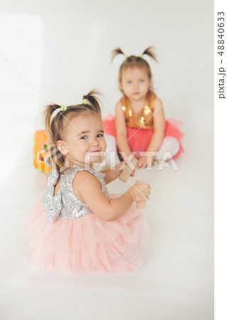 two little girls playing on the floor on a white two little girls playing on the floor on a white 48840633