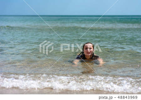A young woman sails on the waves of the Black Sea 48843969