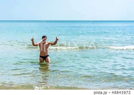 A sports man shows a sign ok in the waves of the 48843972