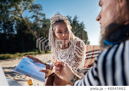 Dark-eyed woman teaching Chinese her boyfriend while resting in nature Dark-eyed woman teaching Chinese her boyfriend while resting in nature 48845662