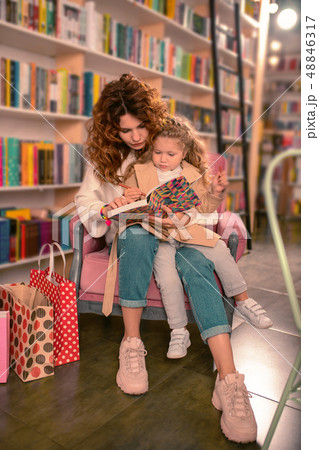 Attentive young woman reading tale for her kid 48846317