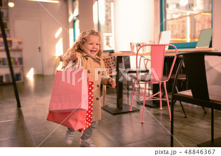 Happy blonde girl running with shopping bags 48846367