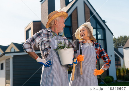 Smiling joyful couple standing next to the house Smiling joyful couple standing next to the house 48846697