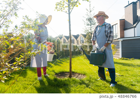 Pleasant involved couple spending time together in the garden Pleasant involved couple spending time together in the garden 48846766