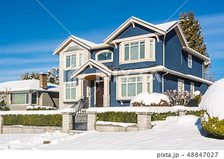 Luxury residential house with front yard in snow on winter sunny day 48847027
