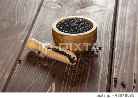 Black lentils beluga on brown wood 48848039
