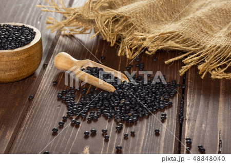 Black lentils beluga on brown wood Black lentils beluga on brown wood 48848040