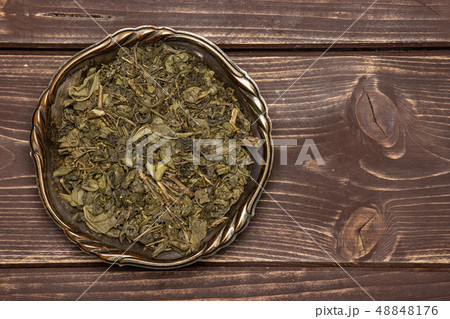 Dry green tea on brown wood 48848176