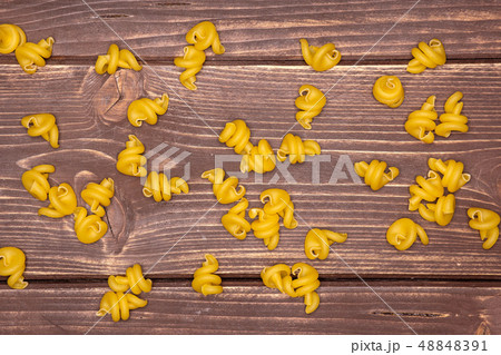 Raw pasta funghetto on brown wood Raw pasta funghetto on brown wood 48848391