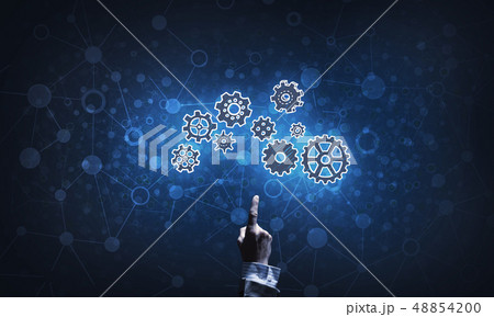 Glowing cogwheel mechanism icon on dark background as symbol of teamwork 48854200