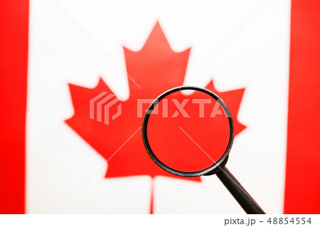 The flag of CANADA looks through a magnifying The flag of CANADA looks through a magnifying 48854554