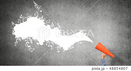 Hand of man holding orange paper trumpet against concrete background 48854807