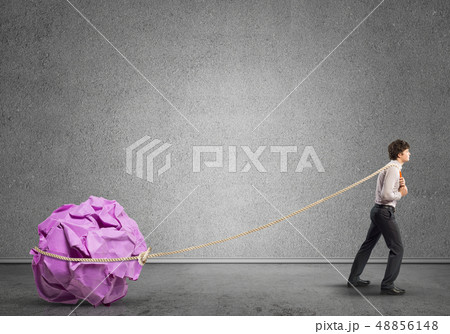 Man pulling with effort big crumpled ball of paper as creativity sign 48856148