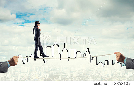 Business concept of risk support and assistance with man balancing on rope Business concept of risk support and assistance with man balancing on rope 48858187