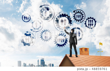 Businessman on house roof presenting teamwork and connection concept. Mixed media Businessman on house roof presenting teamwork and connection concept. Mixed media 48859761