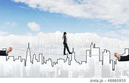 Business concept of risk support and assistance with man balancing on rope Business concept of risk support and assistance with man balancing on rope 48860950
