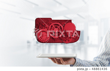 Close of businessman holding tablet pc with engine presenting teamwork and cooperation Close of businessman holding tablet pc with engine presenting teamwork and cooperation 48861436
