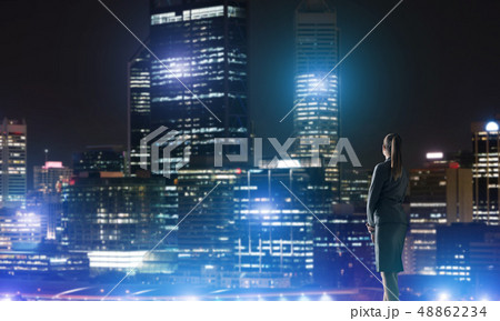 Woman looking at night city Woman looking at night city 48862234