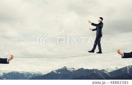 Business concept of risk support and assistance with man balancing on rope 48862381