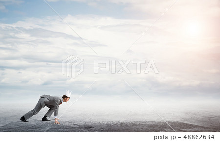King businessman in elegant suit running and blue sky at background King businessman in elegant suit running and blue sky at background 48862634