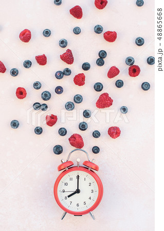 Composition with berries and red alarm clock Composition with berries and red alarm clock 48865668