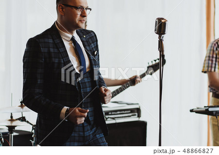 Man in elegant black jacket and blue shirt singing 48866827