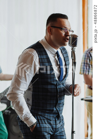 Retro fifties singer with vintage microphone and sunglasses. Studio shot 48866872