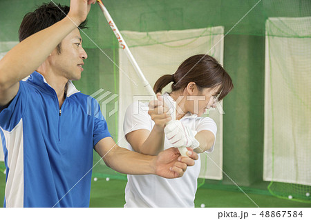 ゴルフ練習場でゴルフを教わる女性 ゴルフ練習場でゴルフを教わる女性 48867584