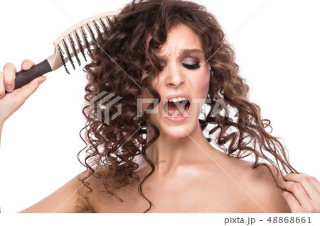 Beautiful brunette girl with a perfectly curly hair with a hairbrush, and classic make-up. Beauty Beautiful brunette girl with a perfectly curly hair with a hairbrush, and classic make-up. Beauty 48868661