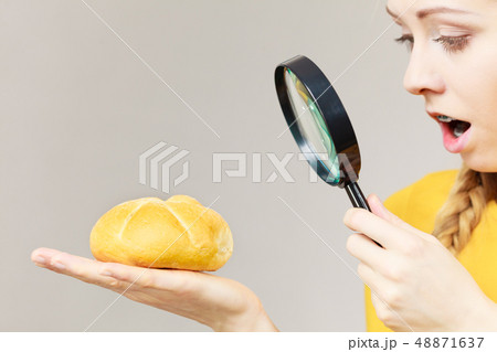 Shocked woman magnifying bun bread roll 48871637