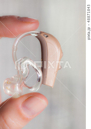 senior person holding hearing aid closeup 48871843