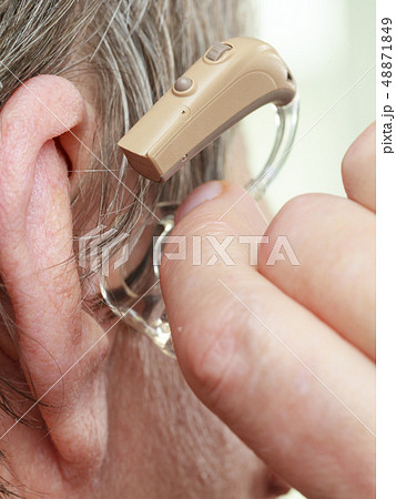 Closeup senior woman using hearing aid 48871849