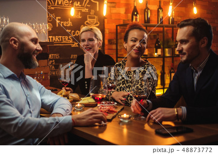 Group of friends having fun talk behind bar counter in a cafe Group of friends having fun talk behind bar counter in a cafe 48873772