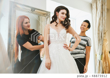Beautifu bride choosing wedding dress in a wedding salon Beautifu bride choosing wedding dress in a wedding salon 48873912
