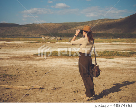 Beautiful woman with binoculars at savanna in Kenya Beautiful woman with binoculars at savanna in Kenya 48874362