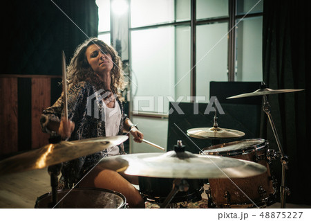 Woman setting drums during music band rehearsal Woman setting drums during music band rehearsal 48875227