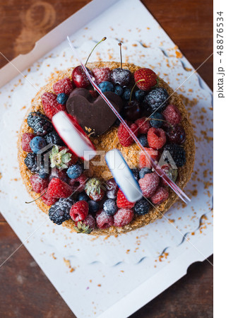 raspberries blackberry birthday cake with candles number 30 on defocused background. Selective focus raspberries blackberry birthday cake with candles number 30 on defocused background. Selective focus 48876534