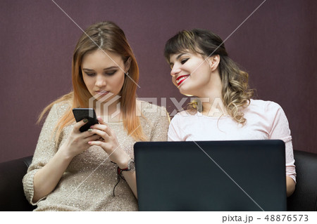 The girl with the phone and the girl with a laptop The girl with the phone and the girl with a laptop 48876573