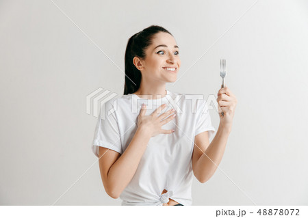 Young fun crazy brunette housewife with fork isolated on white background Young fun crazy brunette housewife with fork isolated on white background 48878072