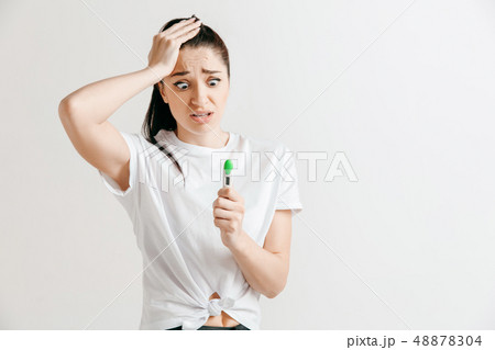Young woman looking on pregnancy test Young woman looking on pregnancy test 48878304
