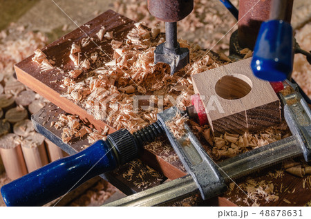 The master makes a hole in the wooden blank. The master makes a hole in the wooden blank. 48878631