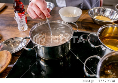 Cook stir the noodles in the pan. Master class in the kitchen. The process of cooking. Step by step 48879338