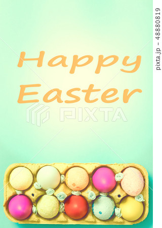 Bright Easter eggs lie in a box on a blue background 48880819
