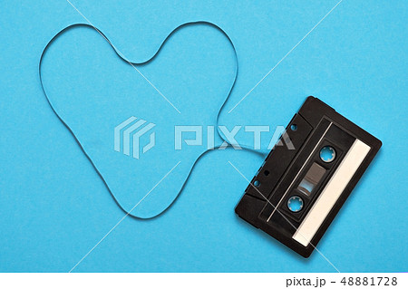 Retro music audio tape on blue baclground. Tape formed in heart sign. Retro music audio tape on blue baclground. Tape formed in heart sign. 48881728