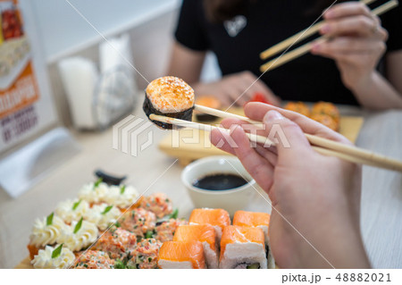 girl eating sushi set with chopsticks on restaurant 48882021