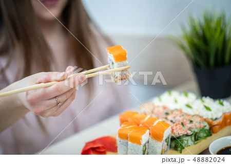girl eating sushi set with chopsticks on restaurant 48882024