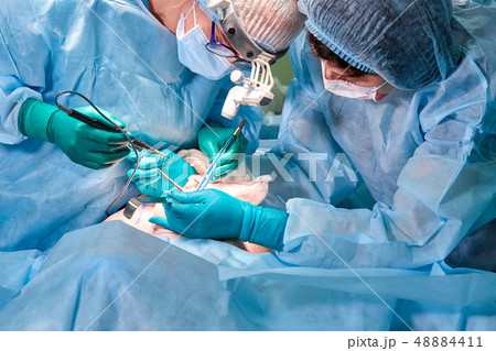 Portrait of a surgeon close-up. Surgeons operate on a patient. Tense, serious faces. Real operation Portrait of a surgeon close-up. Surgeons operate on a patient. Tense, serious faces. Real operation 48884411