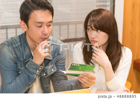 銀行通帳を見つめる男女 銀行通帳を見つめる男女 48888895
