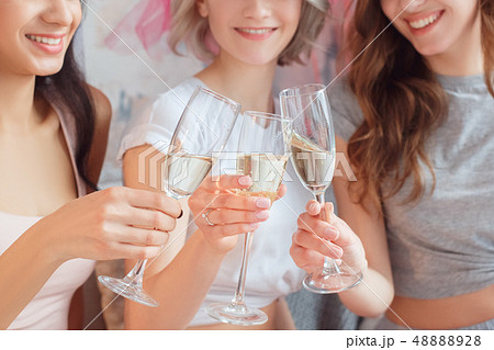 Hen-Party. Young women together at home sitting on sofa drinking champagne cheers smiling cheerful Hen-Party. Young women together at home sitting on sofa drinking champagne cheers smiling cheerful 48888928